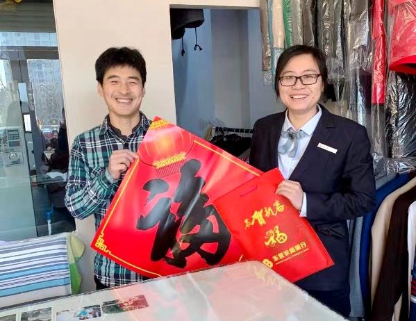 04东营农商银行鑫城支行走进周围商户，开展“迎春送福”活动，为客户送去“福”字及对联，把温暖祝福送到客户身边。（孙金金）_副本